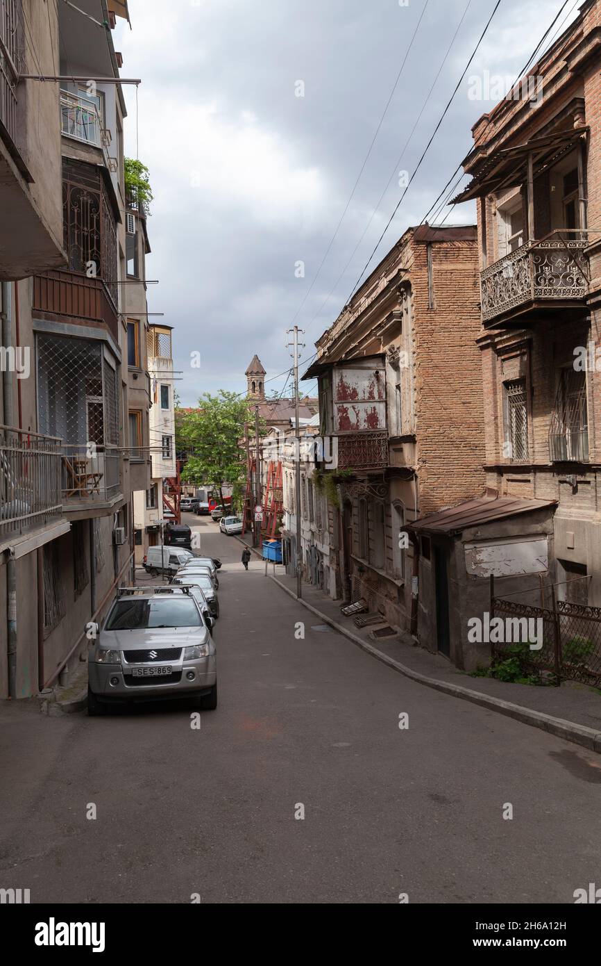 Tbilisi, Georgia - 3 maggio 2019: Vecchia Tbilisi Street view con auto parcheggiate vicino a case viventi, persone a piedi la strada, foto verticale Foto Stock