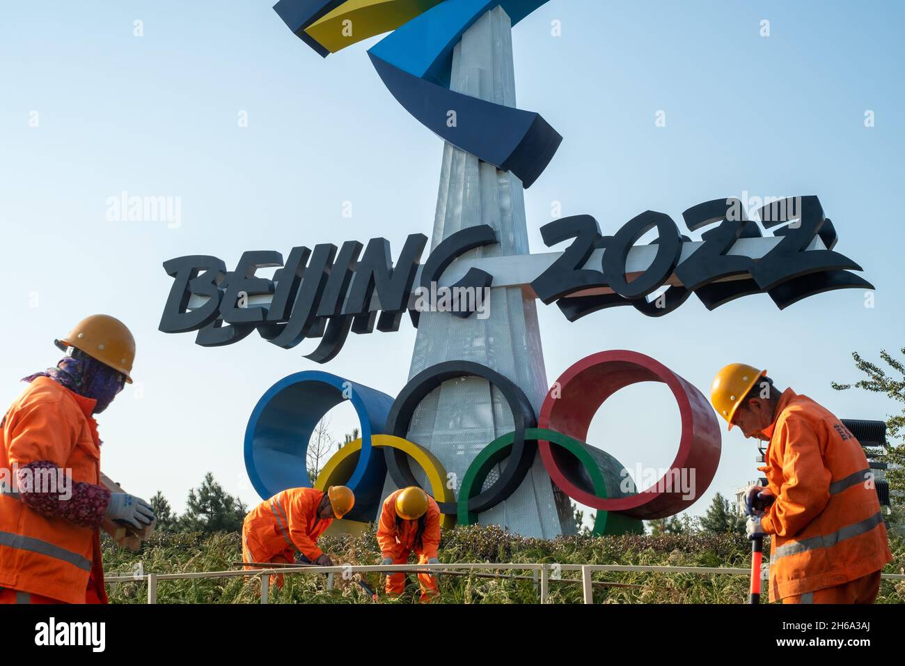 Gli operai ecologici urbani lavorano davanti ad un enorme emblema delle Olimpiadi invernali di Pechino 2022 a Pechino, Cina. 14-Nov-2021 Foto Stock