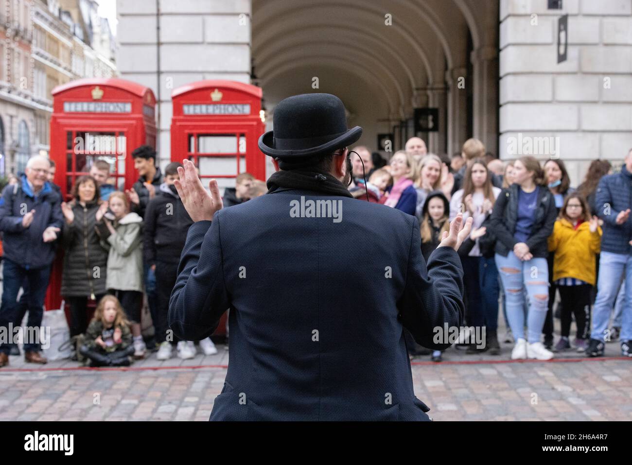 Gli amanti dello shopping si riuniscono per assistere all'intrattenimento Street a Covent Garden Piazza, nel centro di Londra, Inghilterra, Regno Unito Foto Stock