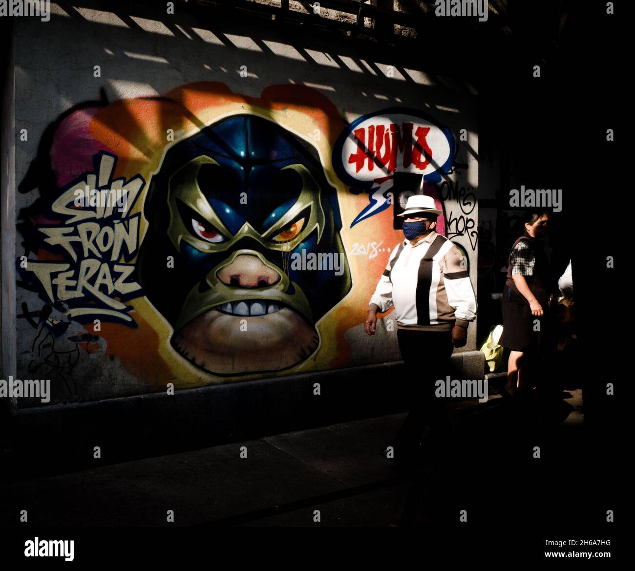 MEXICO CIT, MESSICO - 13 settembre 2021: Un uomo che cammina a Città del Messico di fronte a un muro dipinto con un combattente di lotta Foto Stock