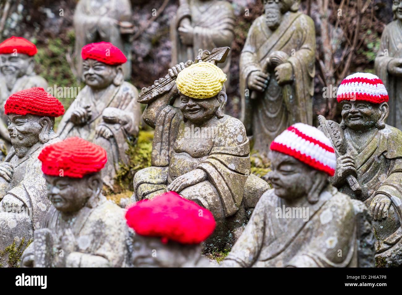 Giappone, Miyajima. Rakan piccole statue di monaci buddisti, discepoli di Shaka, rivestimento gradino di pietra percorso attraverso l'entrata del Daisho-nel tempio. Foto Stock