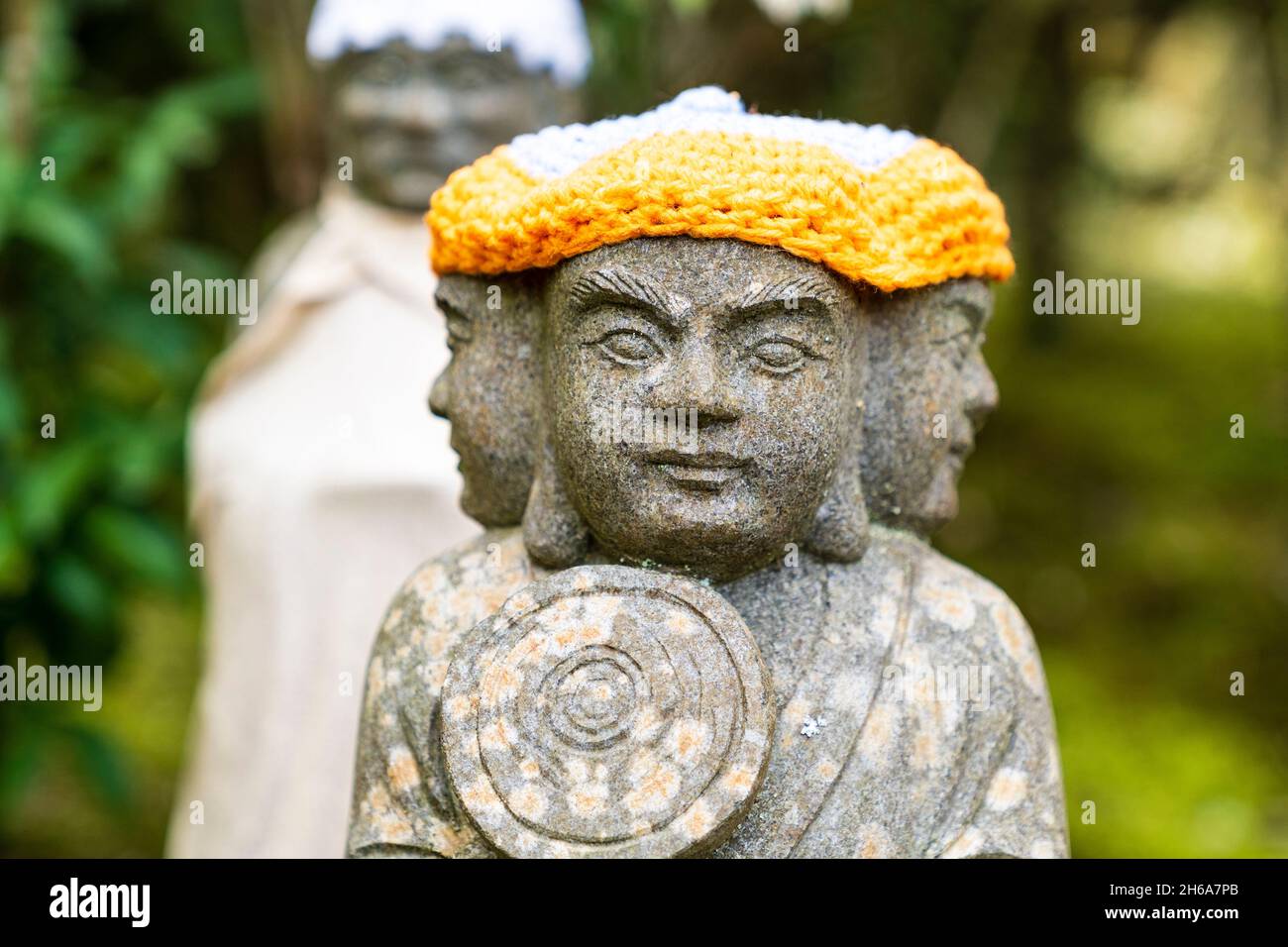 Miyajima. Tempio Daisho-in. Piccola statua Rakan di un monaco buddista, con tre facce rivolte in avanti a sinistra e a destra, e indossa un cappello di lana giallo Foto Stock