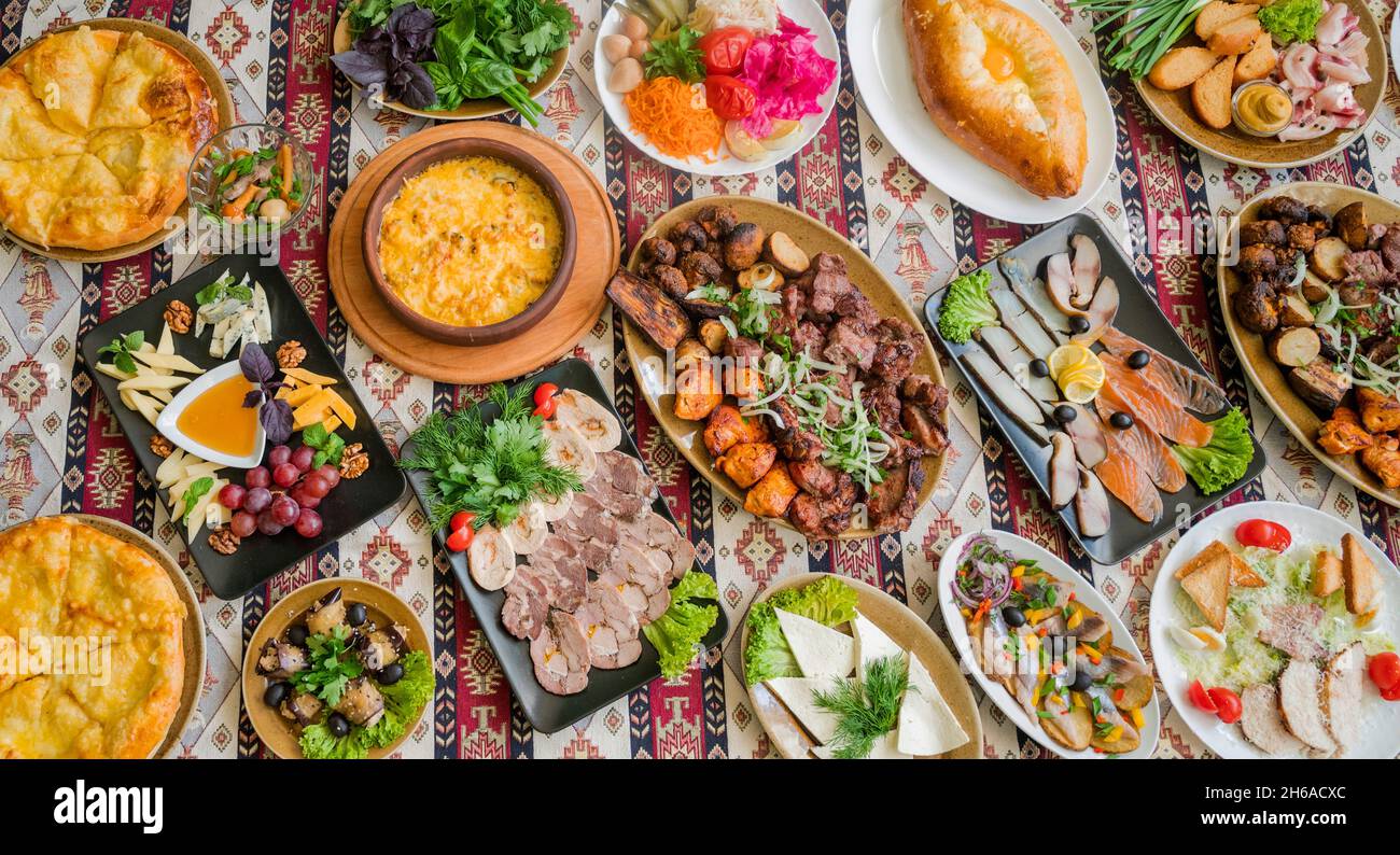 cucina nazionale georgiana e azerbaigiana piatti suluguni cotti khachapuri, funghi e verdure ed erbe con un piatto di formaggi assortiti e s. Foto Stock