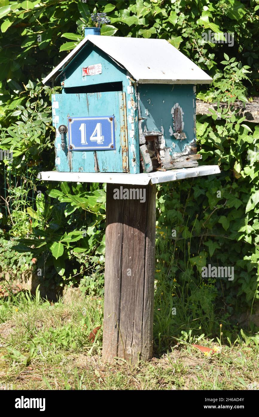 Una mailbox fatta in casa, una scatola in legno color turchese a forma di casa con tetto a falde e l'intera apertura frontale su cerniera a piano Foto Stock