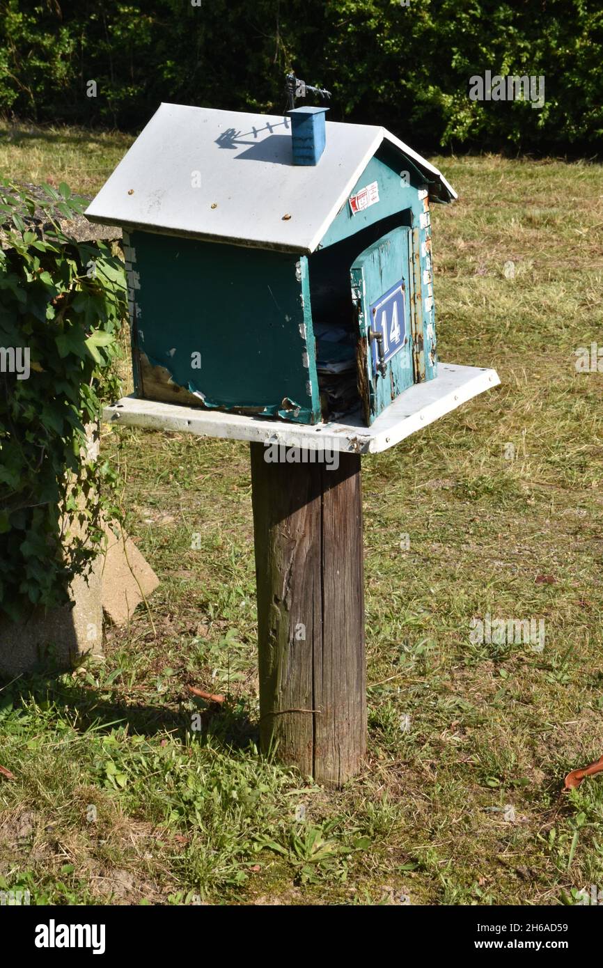 Una mailbox fatta in casa, una scatola in legno color turchese a forma di casa con tetto a falde e l'intera apertura frontale su cerniera a piano Foto Stock
