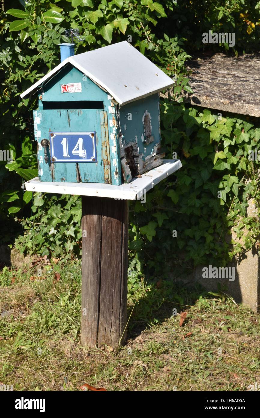 Una mailbox fatta in casa, una scatola in legno color turchese a forma di casa con tetto a falde e l'intera apertura frontale su cerniera a piano Foto Stock