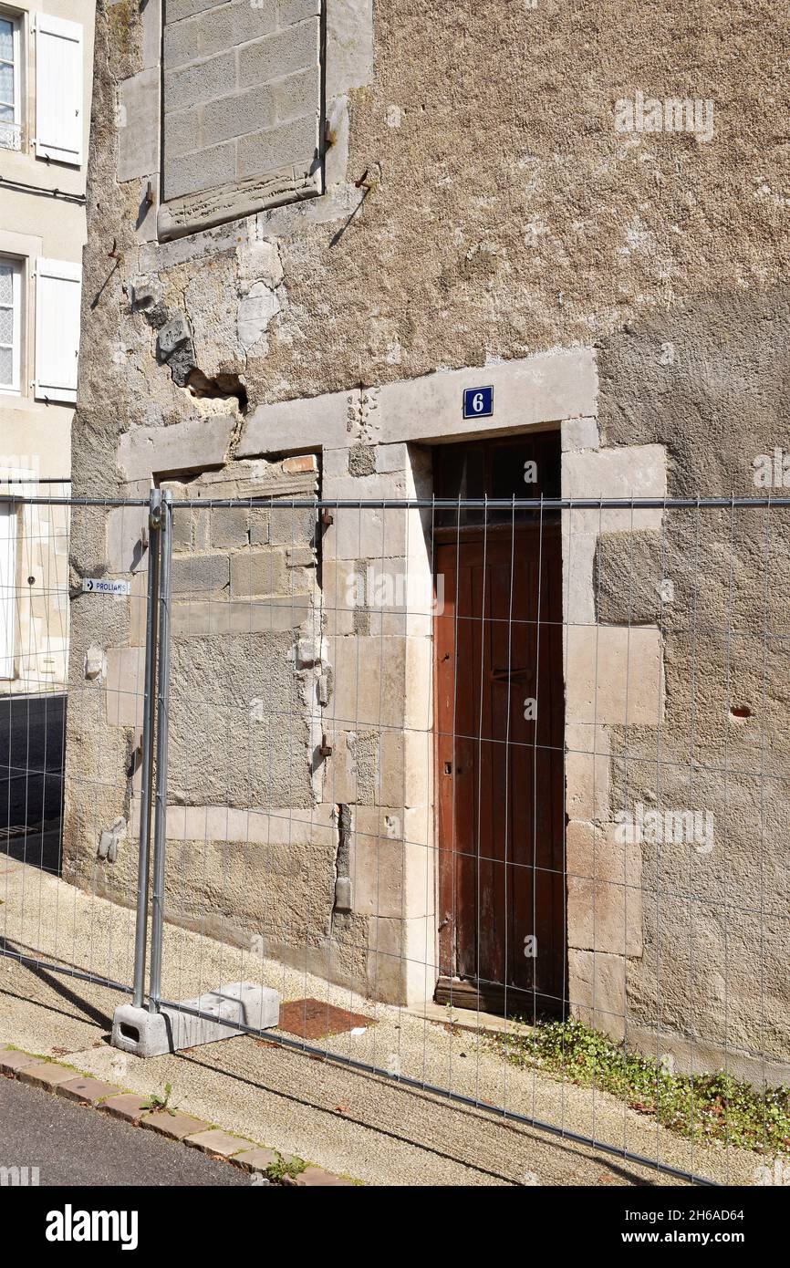 L'angolo di una casa sostanziale a tre piani a Montmorillon, Francia, che sta cominciando a crollare, crepe principali e finestre in-pieno per irrigidirla Foto Stock