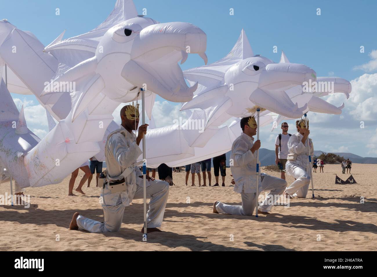 Tre uomini che detengono tre carri bianchi al festival internazionale di aquiloni di Corralejo, novembre 2021. Fuerteventura, Spagna. Foto Stock