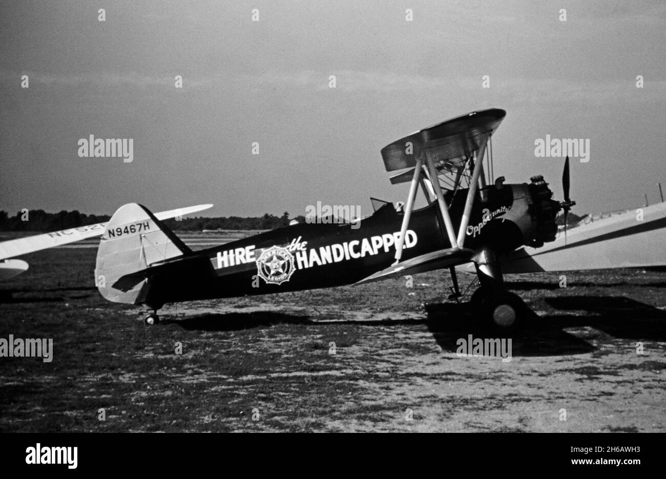 Fotografia d'epoca scattata nel settembre 1948 a Cleveland, Ohio, USA. La foto mostra un aereo in un Airshow o una corsa aerea. Un biplanare Stearman PT-17, numero di serie N9467H. L'aeromobile presenta un emblema "noleggia gli handicappati" sul lato. Foto Stock