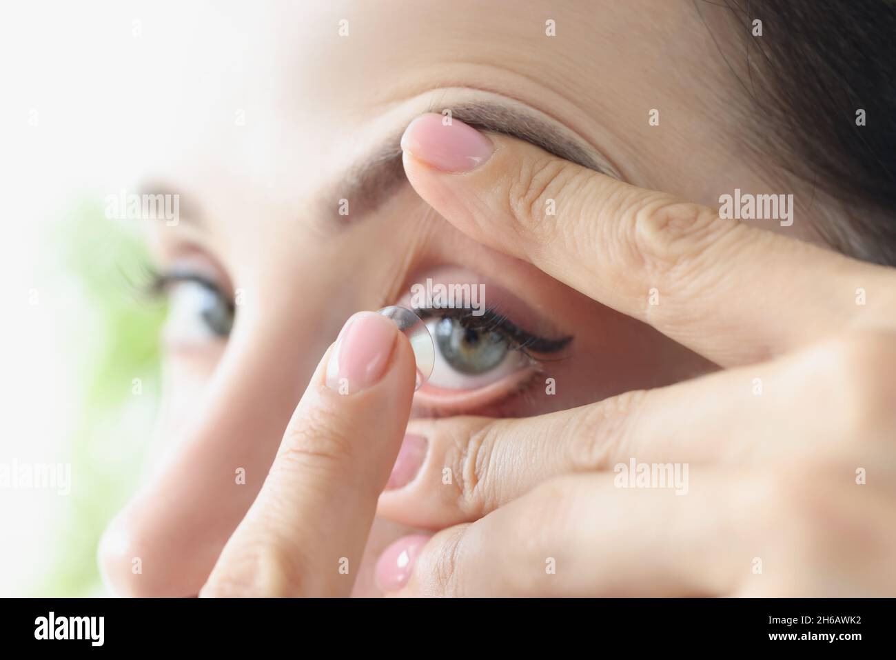 La donna si pone a lungo termine lenti a contatto morbide primo piano Foto Stock