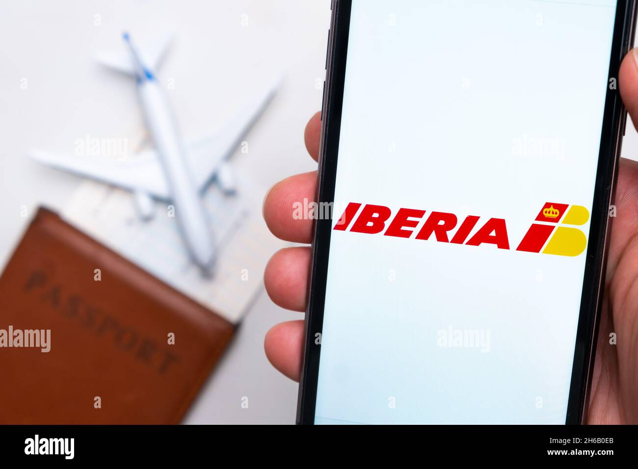 Iberia compagnie aeree logo sulla schermata del telefono cellulare in mano uomo sullo sfondo del passaporto, carta d'imbarco e aereo, settembre 2021, San Francisco, USA. Foto Stock