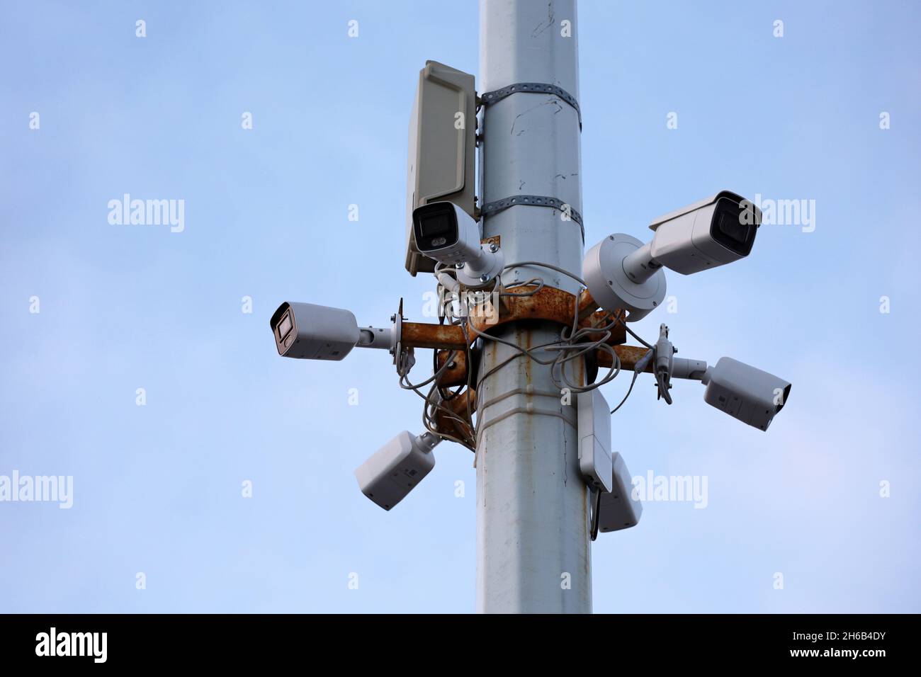 Telecamere di sorveglianza per esterni su un palo in cemento in cielo blu. Telecamera CCTV, concetto di sicurezza, privacy e protezione dal crimine Foto Stock