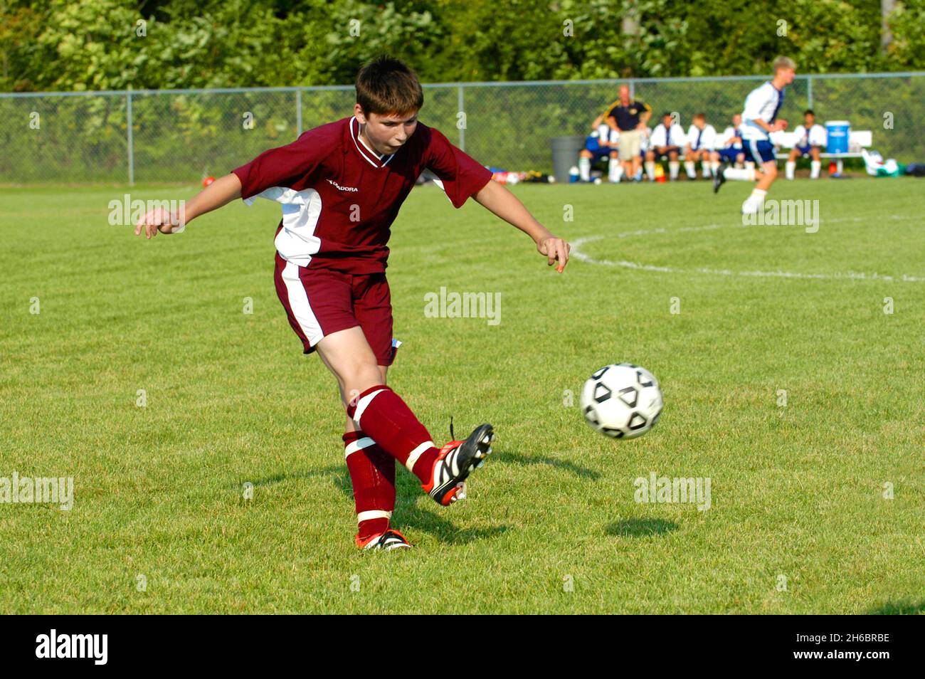 Ragazzi High School calcio americano azione con ragazzo calcio calci palla Foto Stock