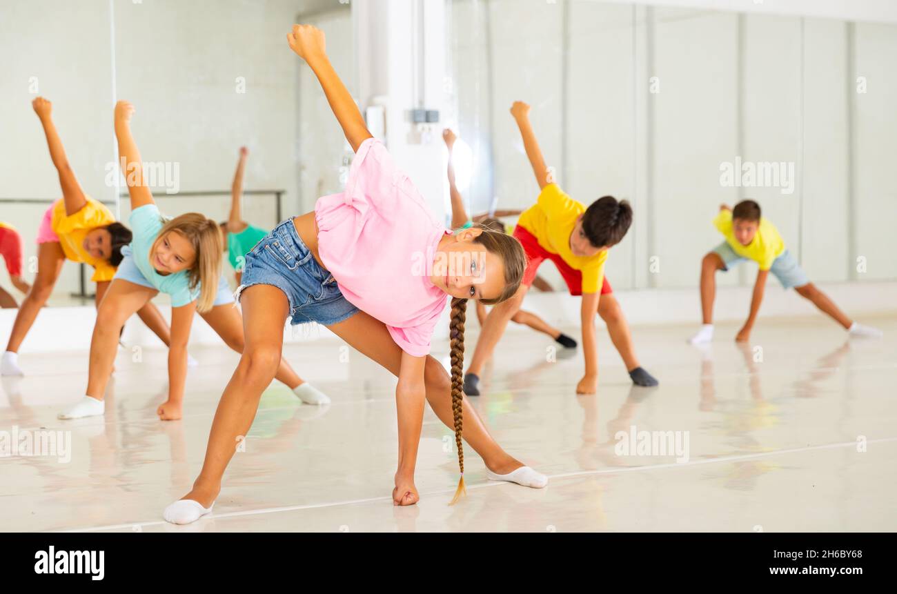 Ragazza sportiva di dieci anni che fa stretching warm-up in classe di danza Foto Stock