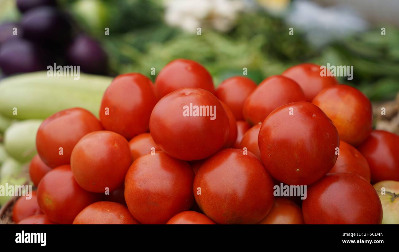 Immagine ad alta risoluzione: Venditore di pomodori e pomodori in un vivace mercato indiano #pomodoro, venditore di pomodori, #india, #vegetablemarket Foto Stock