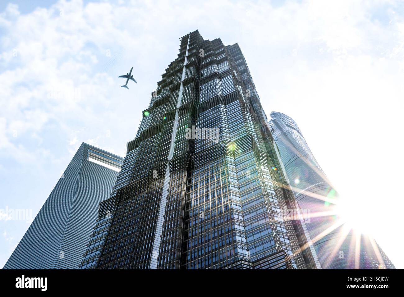 Moderni edifici di Shanghai e grattacieli con l'aereo che vola sopra e il sole scoppiò Foto Stock