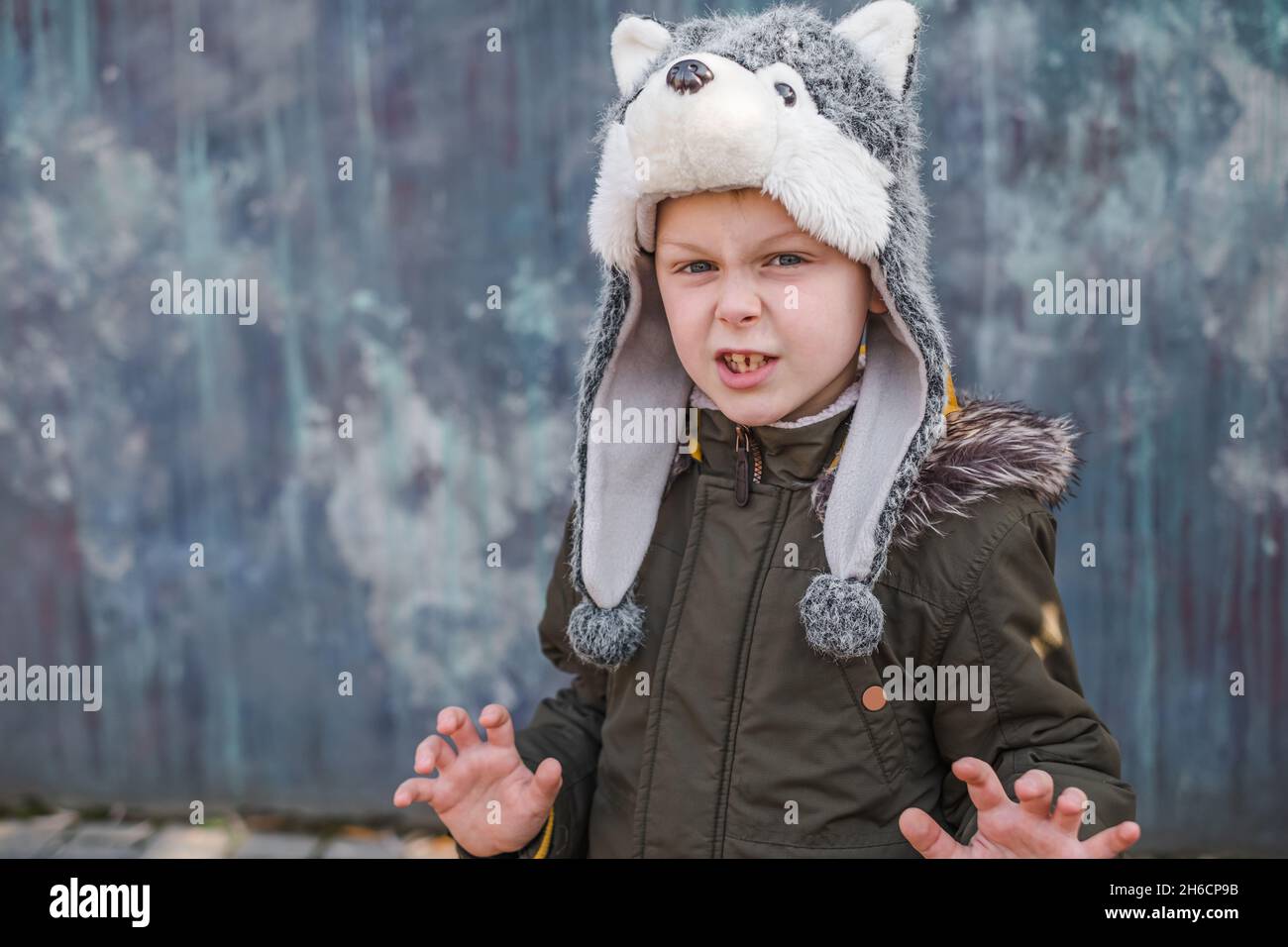 Bambino in un cappello lupo su sfondo grigio, all'aperto. Foto di alta  qualità Foto stock - Alamy