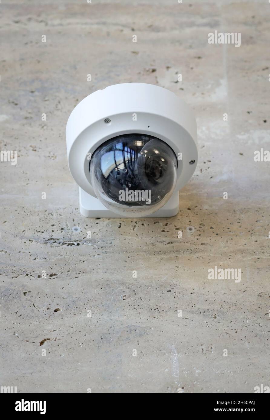 Dettagli con una telecamera CCTV su una parete all'interno di un edificio. Foto Stock