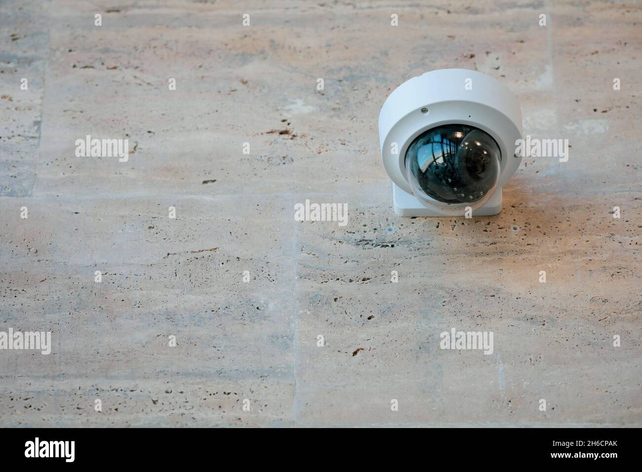 Dettagli con una telecamera CCTV su una parete all'interno di un edificio. Foto Stock