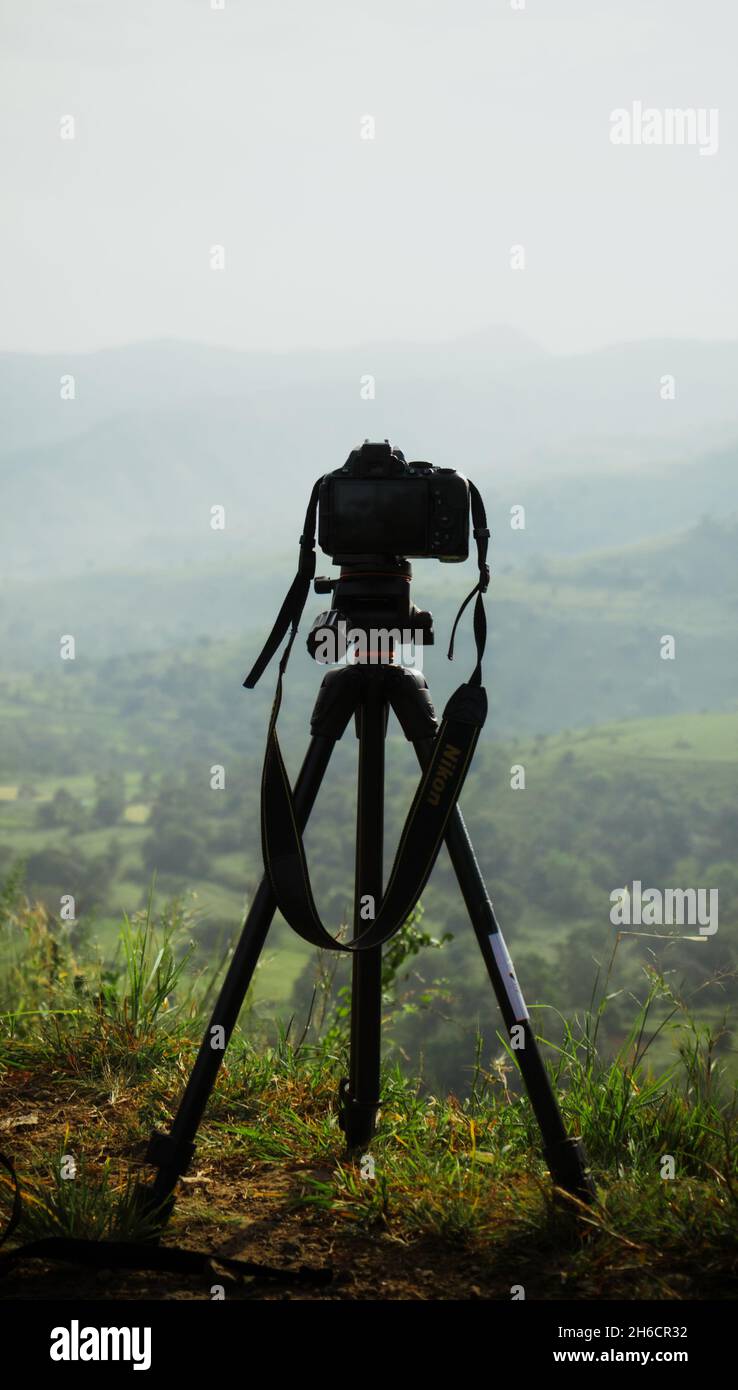 una fotocamera montata su un cavalletto che punta verso un paesaggio Foto Stock