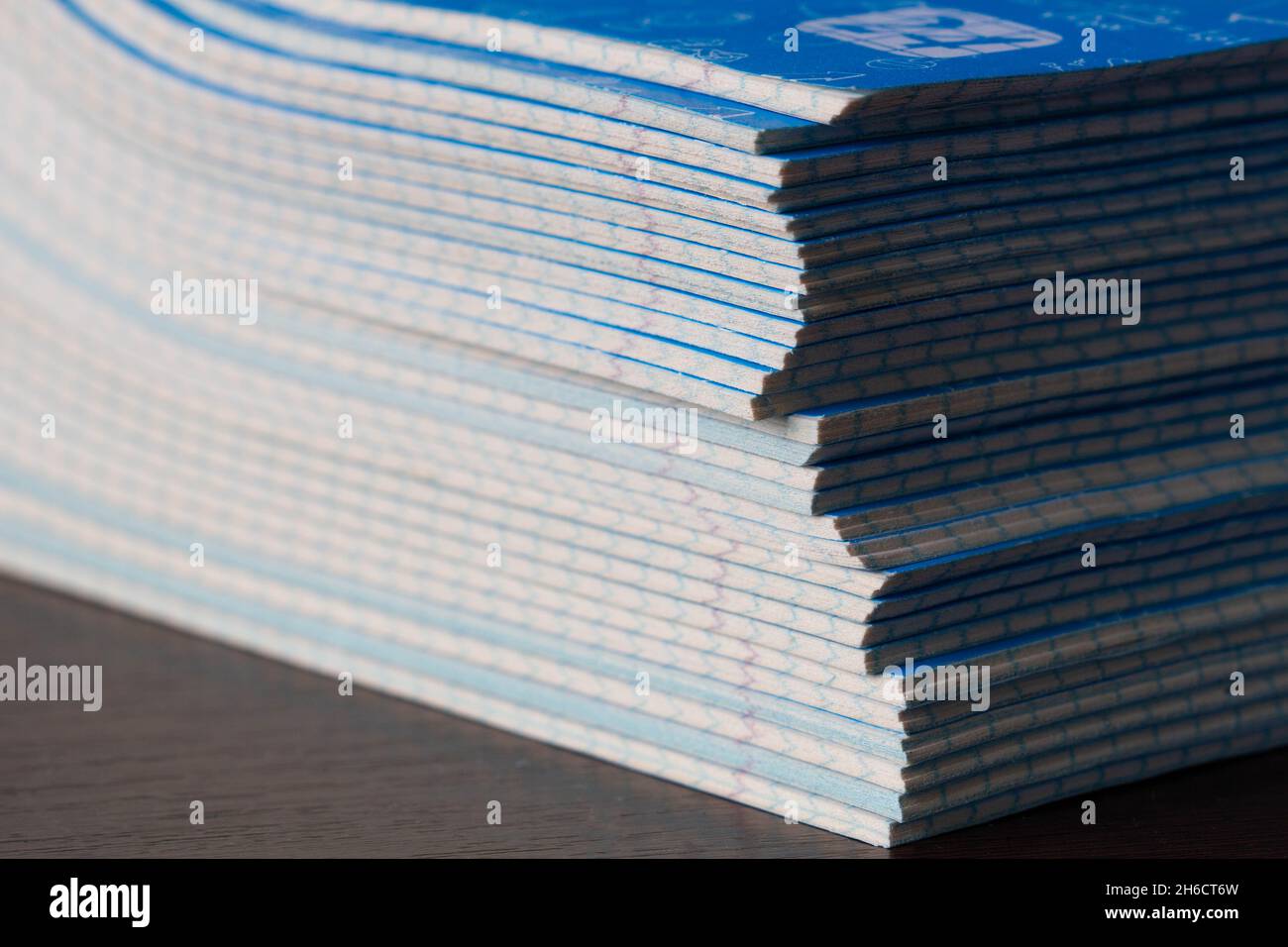 Stack di notebook. Ritorno a scuola. Una confezione di taccuini blu scuola sul tavolo in una classe. Pila di libri di esercizi. Pacchetti matematici a scacchi Foto Stock