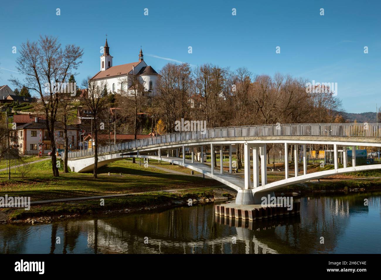 Chiesa di Piwniczna con fiume Poprad e ponte in primo piano Foto Stock