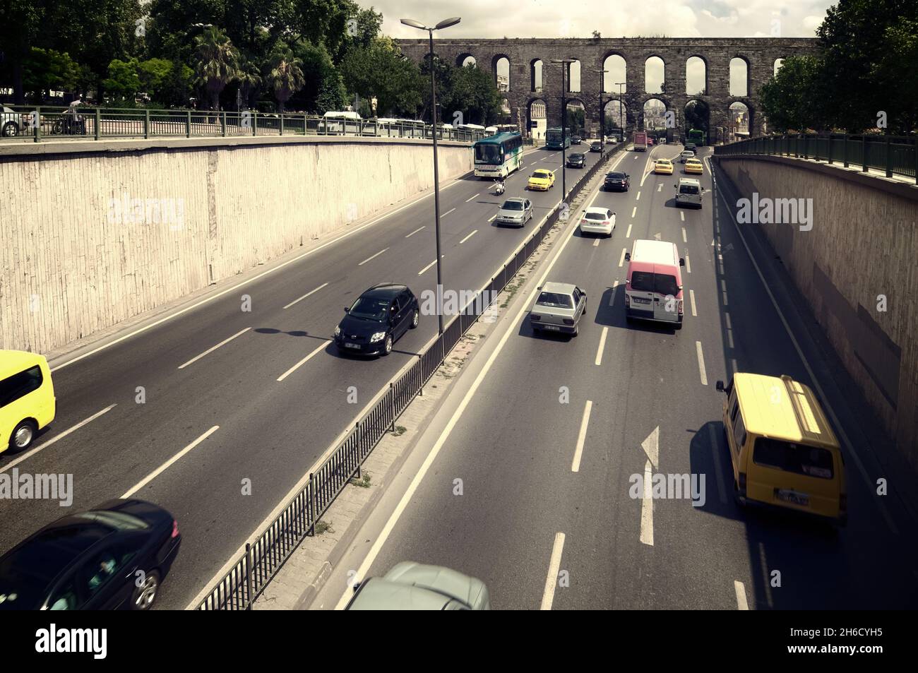 Costantinopoli storica e Istanbul contemporanea l'antico Acquedotto romano di Valens e il moderno traffico di strada che attraversa sotto gli archi impilati Foto Stock