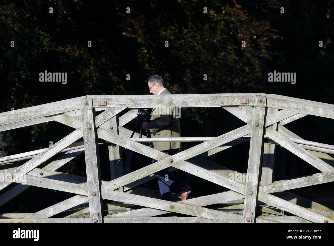 Un membro del Queens' College, Cambridge University, Inghilterra, attraversa il ponte matematico sopra la camma del fiume. Foto Stock