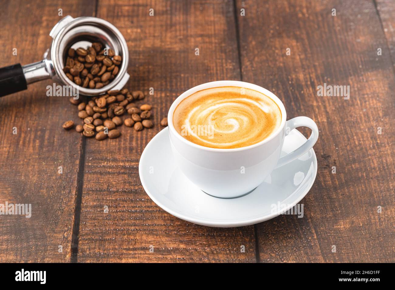 Caffè cappuccino fresco decorato con chicchi di caffè su un tavolo di legno Foto Stock