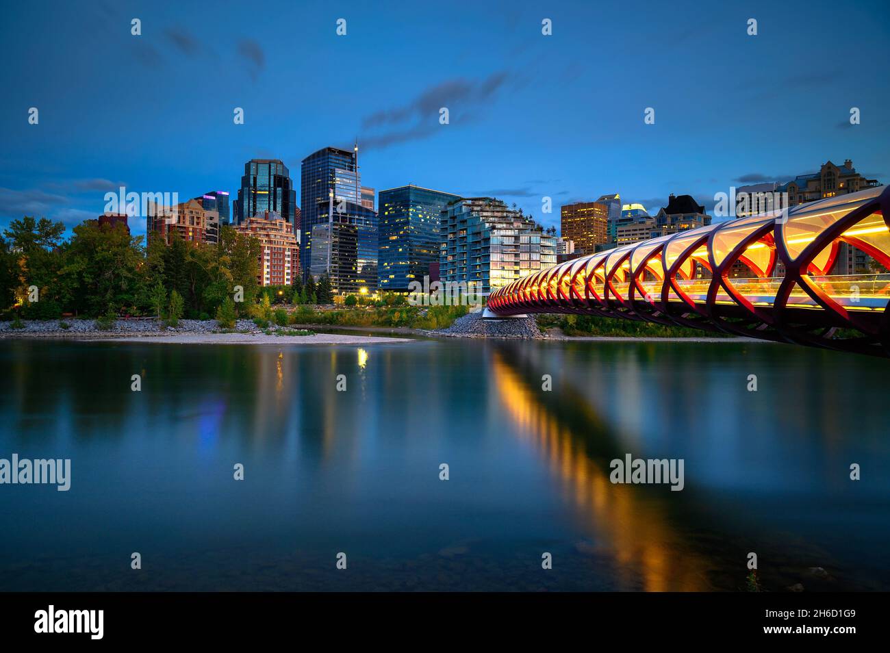 Peace Bridge attraverso il fiume Bow e lo skyline di Calgary fotografato di notte Foto Stock