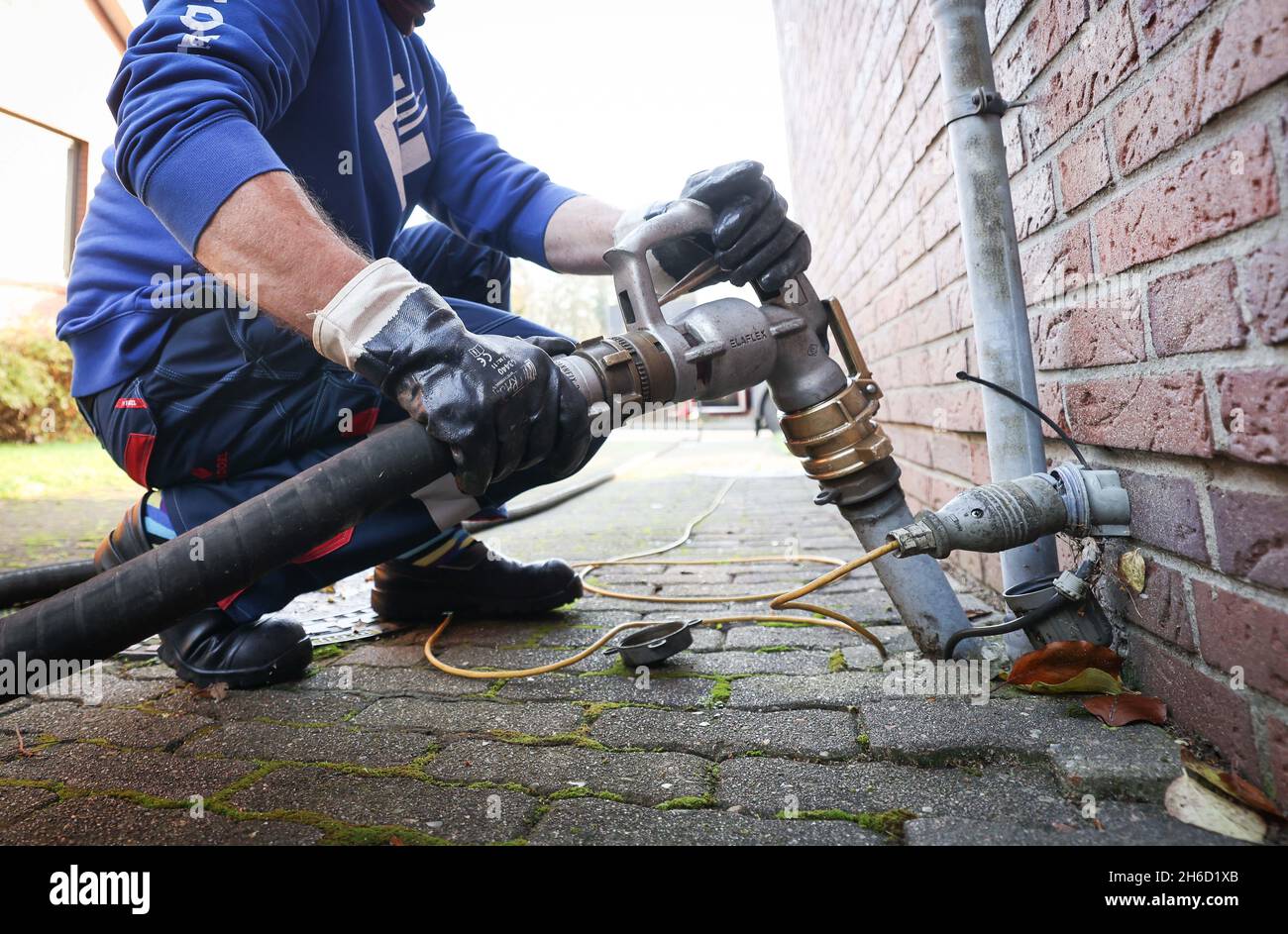 Itzehoe, Germania. 9 novembre 2021. Un dipendente di un'azienda produttrice di gasolio e olio per riscaldamento fissa l'ugello a un bocchettone di rifornimento per la consegna dell'olio per riscaldamento a un cliente in un'unica residenza familiare. Credit: Christian Charisius/dpa/Alamy Live News Foto Stock