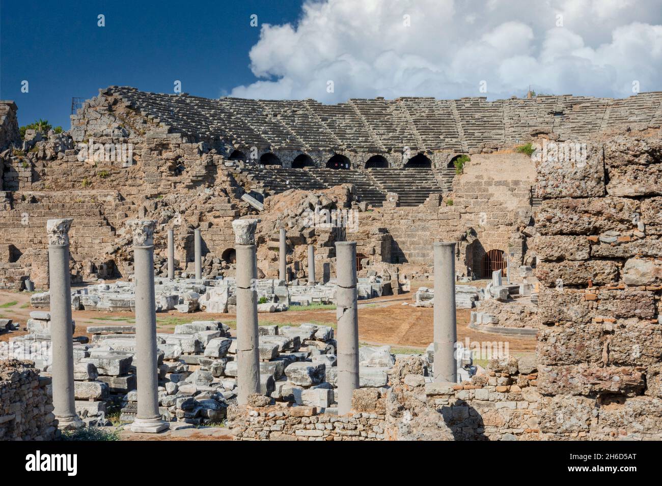 Vista esterna del teatro antico laterale, agora e piazza colonnata. Cielo nuvoloso blu. Rovine selettive del fuoco. Foto Stock