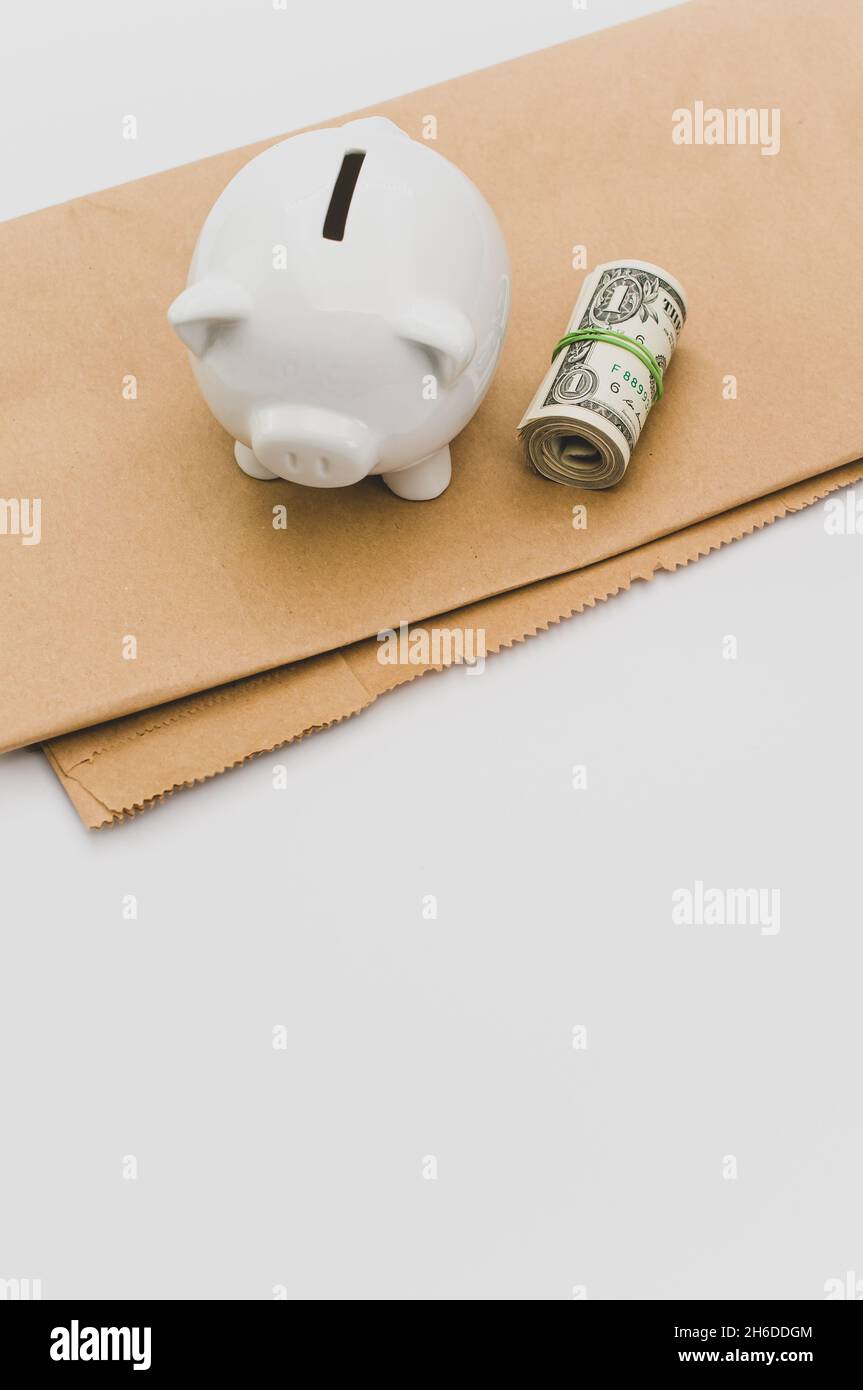banconote e carta bianca ancora banca su un sacchetto di carta marrone  piegato su uno sfondo bianco Foto stock - Alamy