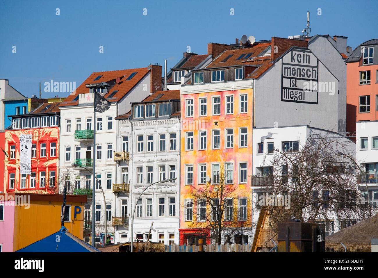 Case colorate nella Hafenstrasse ad Amburgo, scritte 'kein mensch ist illegale' su un muro di casa , Germania, Amburgo, St. Pauli, Amburgo Foto Stock