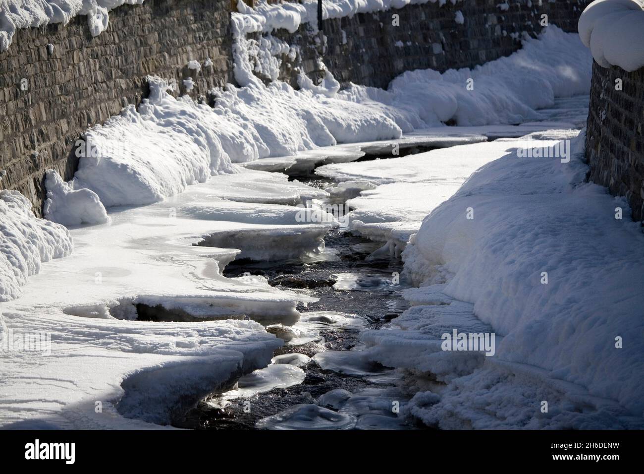 Ruscello innevato e parzialmente congelato, Austria Foto Stock