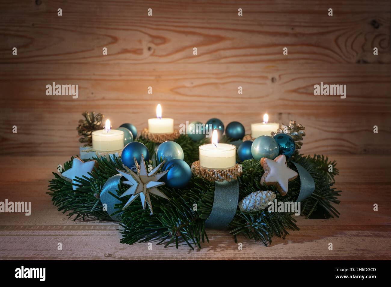 Corona dell'Avvento con quattro candele accese, baubles di Natale turchese blu e decorazione festiva su legno rustico caldo, spazio copia, fuoco selezionato, stretto d Foto Stock