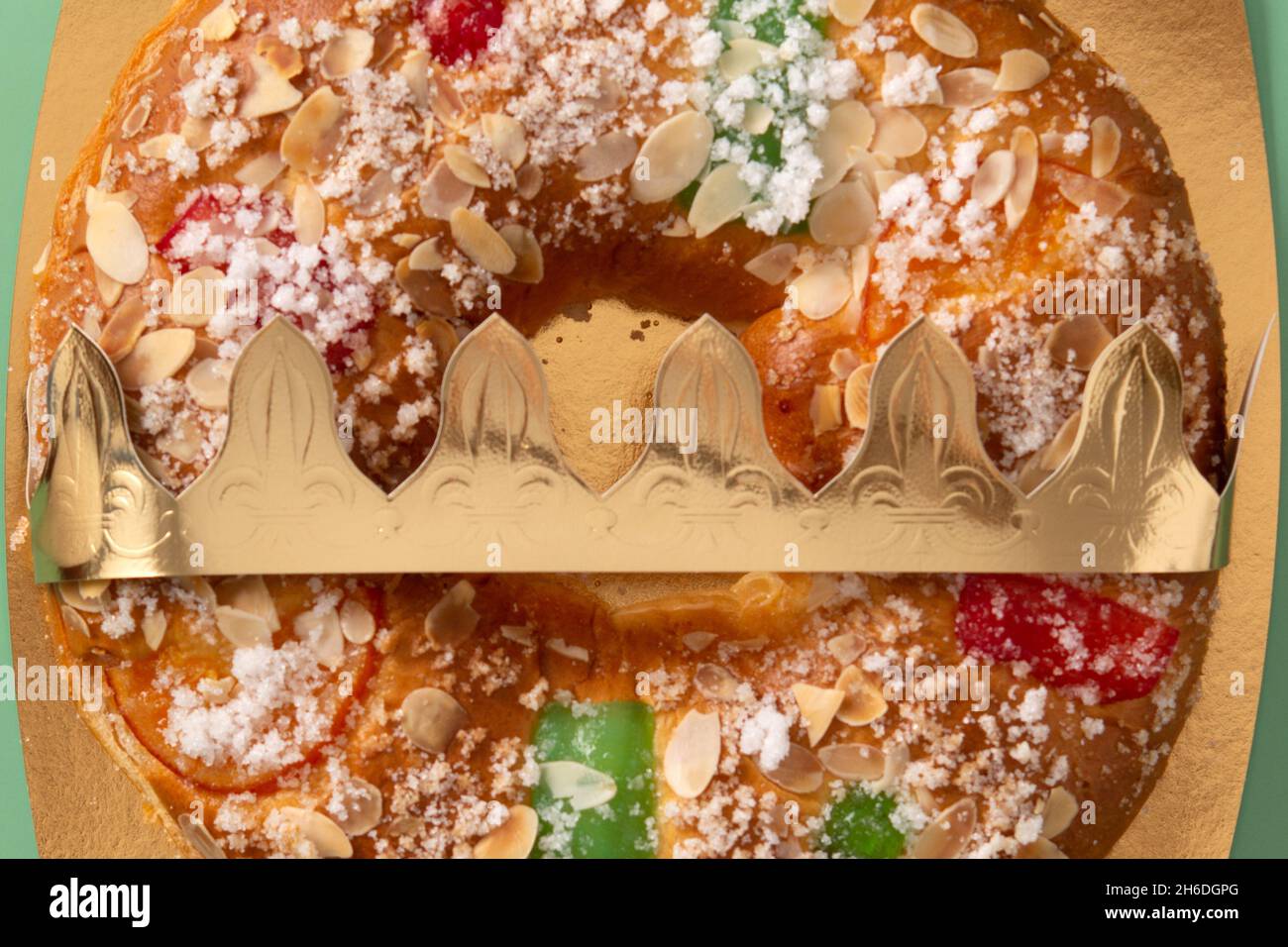 Torta tipica spagnola 'Roscon de Reyes' su sfondo verde Foto Stock