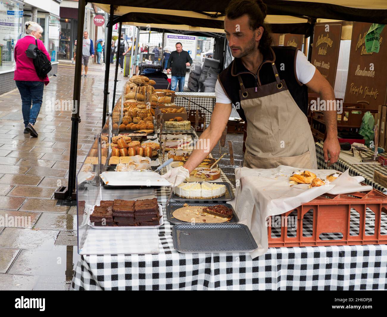 Bancarella di mercato che vende pane e torte, Lymington, Hampshire, Regno Unito Foto Stock