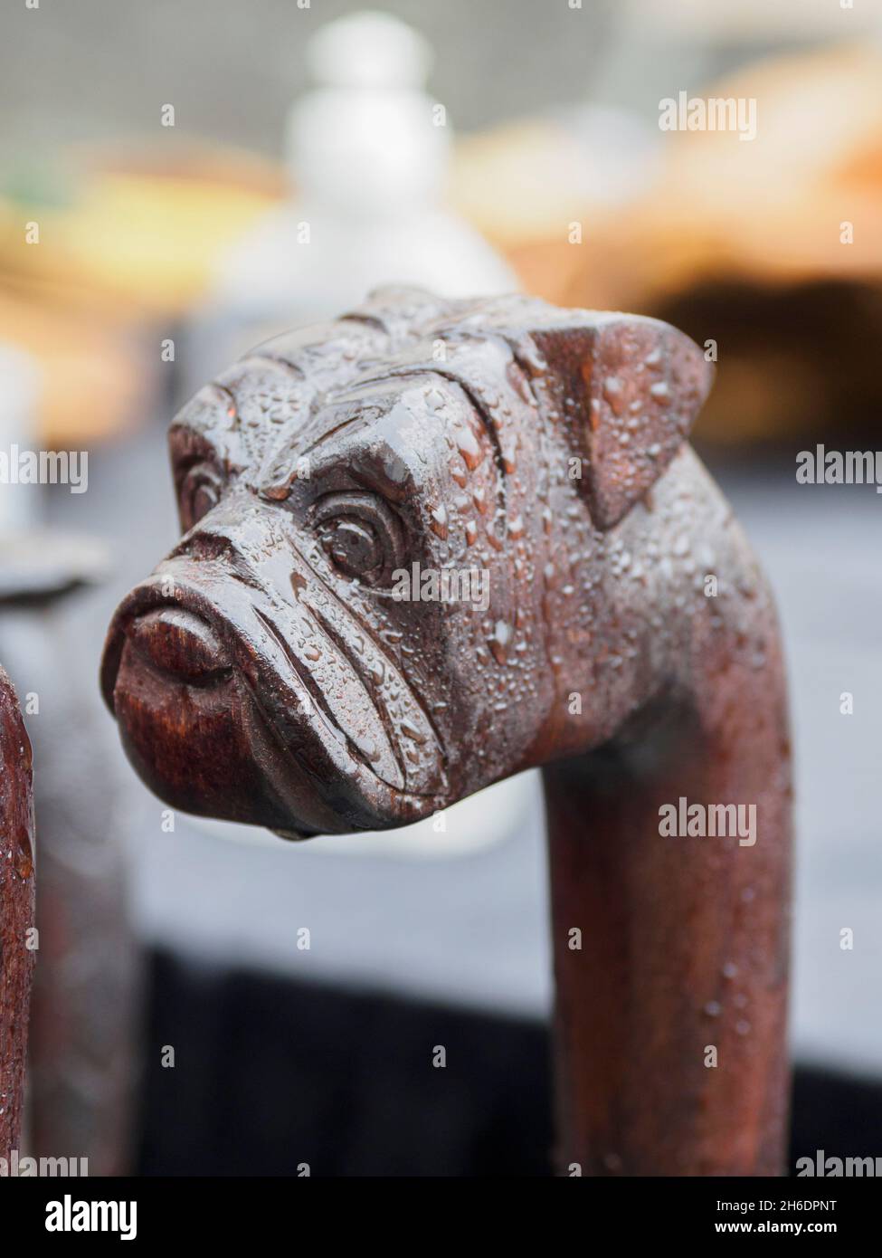 Cani di legno intagliati testa bastone a piedi per la vendita su una bancarella del mercato, Lyminton, Hampshire, Regno Unito Foto Stock