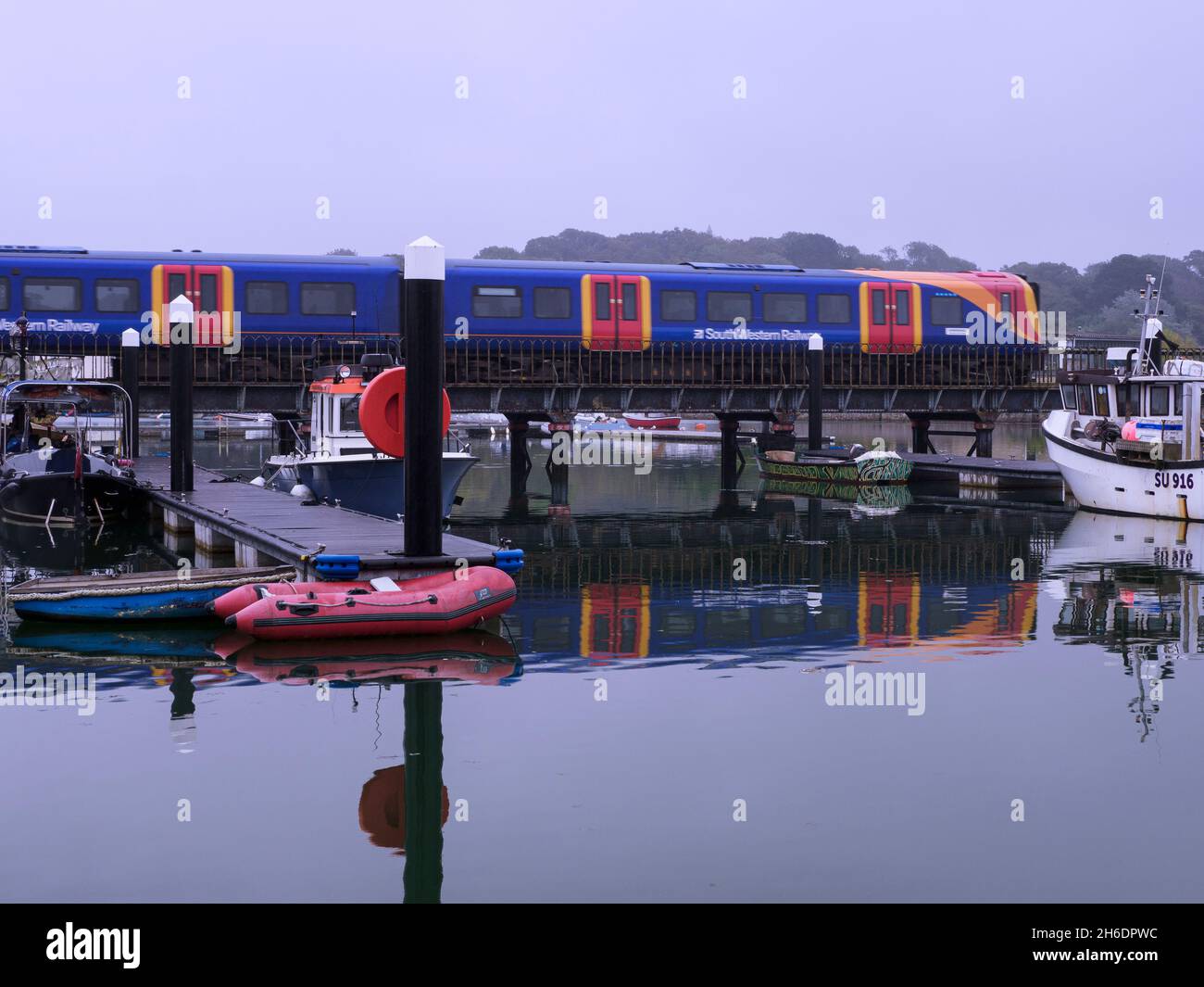 Treno della ferrovia sud-occidentale che attraversa il ponte al porto di Lymington, Hampshire, Regno Unito Foto Stock