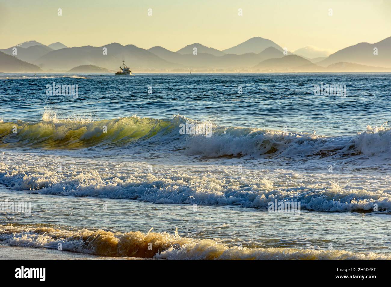 Alba sulla spiaggia del diavolo a Ipanema a Rio de Janeiro con una barca da pesca e montagne sullo sfondo. Foto Stock