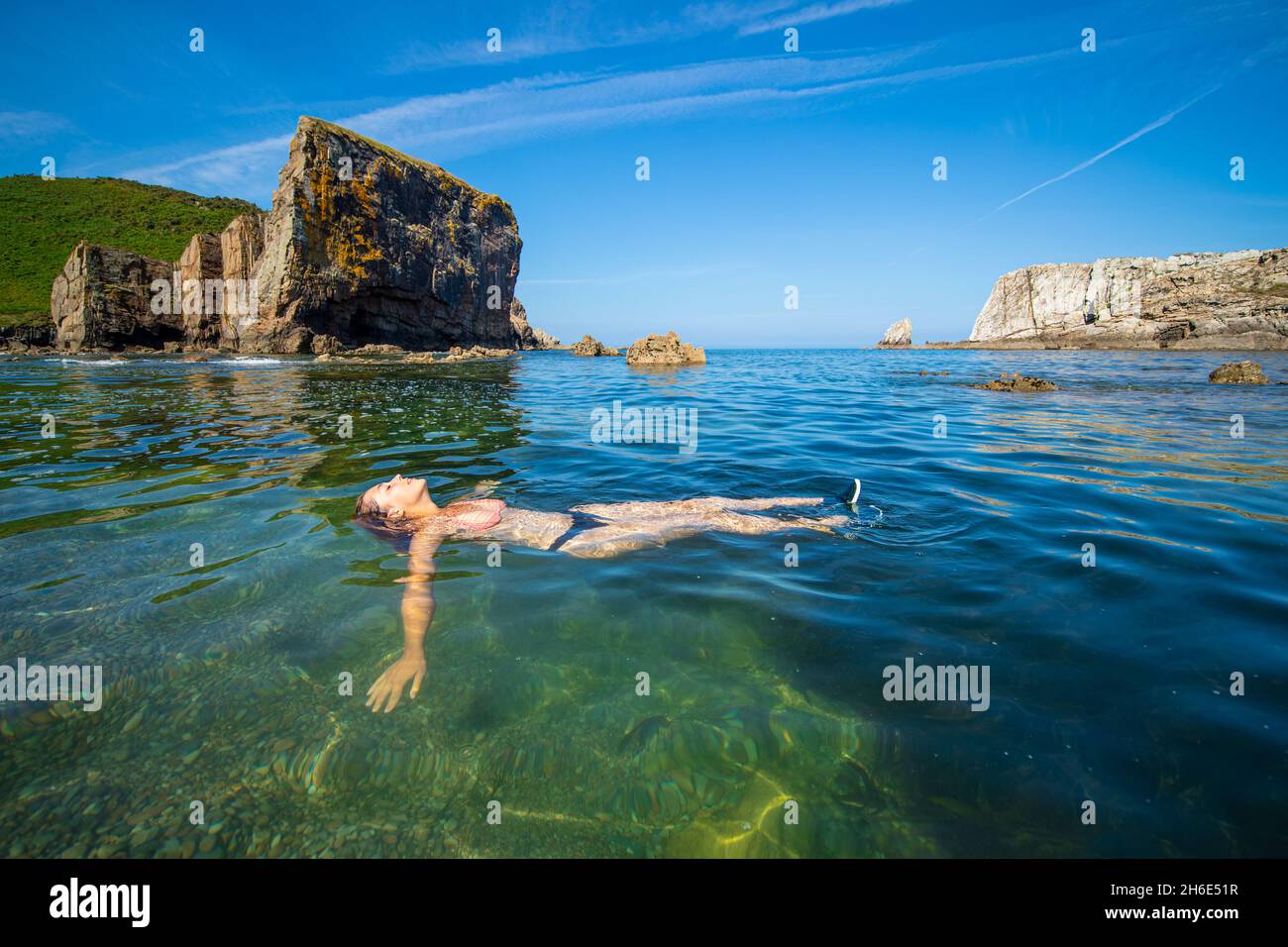 Ritratto a corpo pieno di una donna turistica rilassata che galleggia  sull'oceano di una spiaggia paradisiaca Foto stock - Alamy