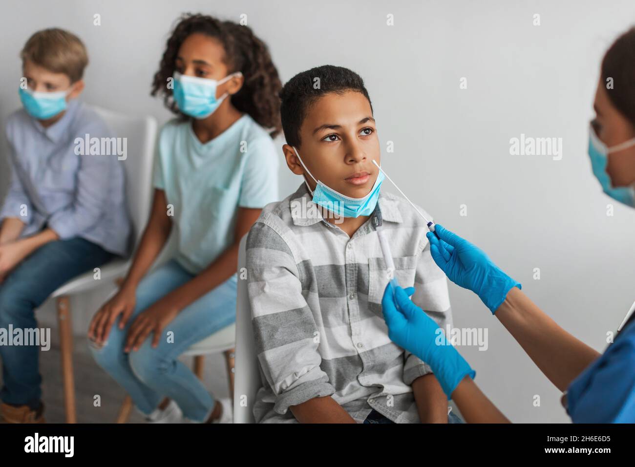 African American Boy Getting saggied for Covid-19 Antigen in Clinic Foto Stock