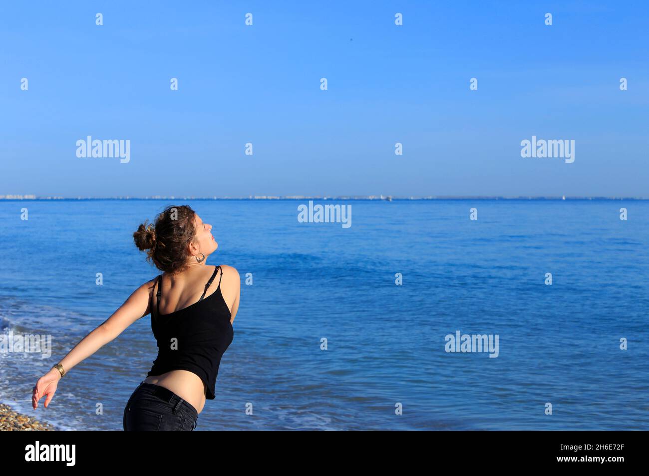 Giovane donna su una spiaggia mediterranea in inverno in Occitanie, Francia Foto Stock
