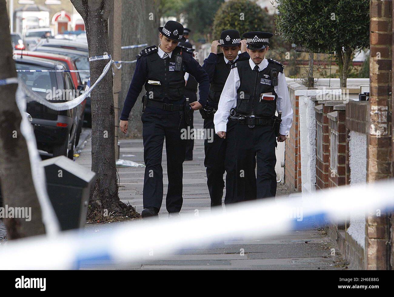 La famiglia e gli amici visitano la scena dove un ragazzo di 15 anni è morto di ferite da pugnale dopo un attacco di coltello per strada. I detective stanno cacciando i suoi attaccanti che hanno messo sopra l'adolescente a Edmonton, Londra del nord, la notte scorsa. Egli è il quarto adolescente a morire nella capitale quest'anno. Foto Stock