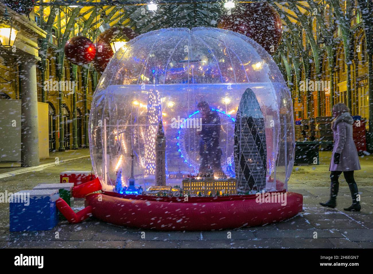 Il primo inverno di Londra, le ''˜nevicate''s''atterra nella Piazza Ovest di Covent Garden per celebrare il lancio del primo LEGO Snow Globe al mondo. Alto oltre 3 metri e realizzato con 120,000 mattoni, lo Snow Globe presenta una scena festiva di Londra, tra cui Buckingham Palace, il Globe Theatre e lo Shard e sarà aperto al pubblico dal 14 novembre al 22 dicembre. Foto Stock