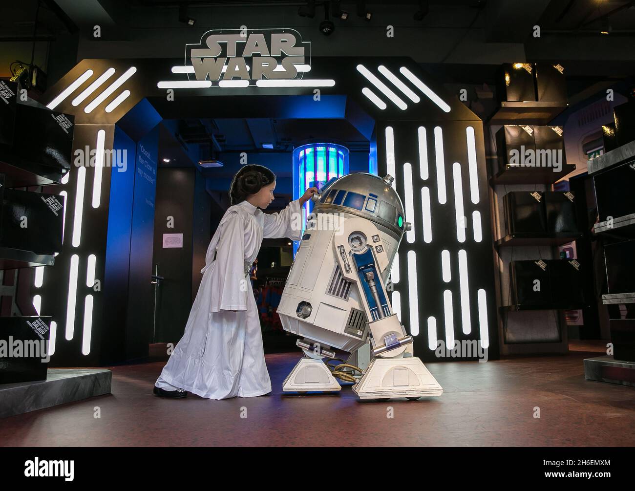 Stormtroopers e R2-D2 si sono Uniti a un giovane fan di Star Wars vestito come Principessa Leia Daisy, di 8 anni al Disney Store di Oxford Street per iniziare il conto alla rovescia finale fino a mezzanotte di stasera, quando la tanto attesa linea di prodotti Star Wars: The Force Awakens sarà lanciata il 4 settembre. Foto Stock