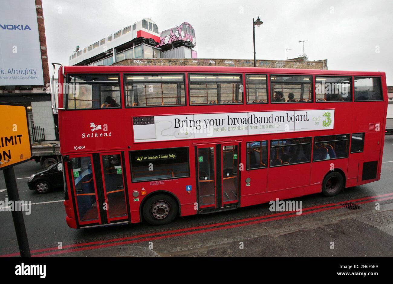 Due carrozze riciclate della metropolitana di Londra sono viste in alto sopra le strade a Shoreditch, Londra orientale. Village Underground a Holywell Lane offre spazio di lavoro conveniente per i creativi a Shoreditch e ha anche trasformato 4,000 m2 di warehousing vittoriano in un centro multi-funzionale di arte, musica e cultura. Foto Stock