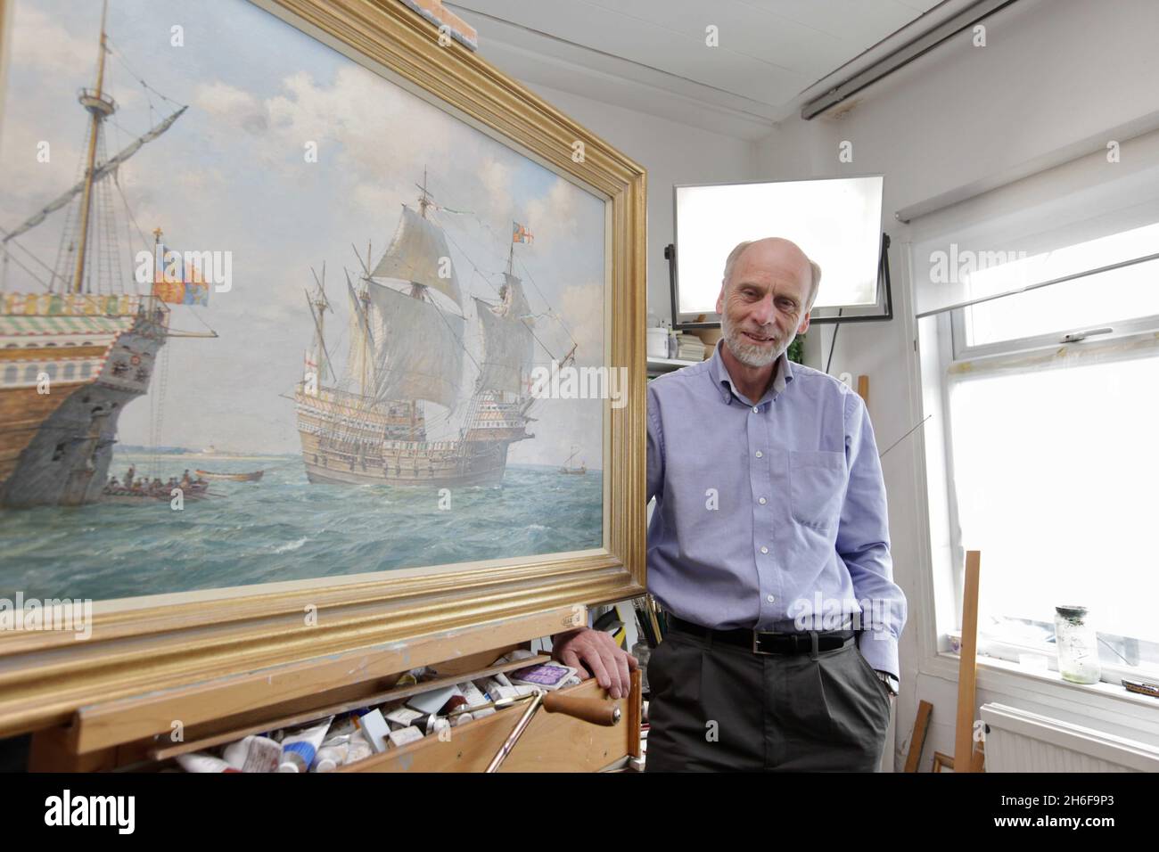 L'artista marino Geoff Hunt con il suo dipinto della Mary Rose nel suo studio di Londra. Si dice che la pittura sia la più accurata dell'ammiraglia di Re Enrico VIII dopo che l'artista ha studiato accuratamente le caratteristiche della nave. Il dipinto è stato commissionato per il 500° anniversario dell'acessione del Re al trono il 21 aprile 1509 e sarà presentato il mese prossimo in occasione di una mostra. Foto Stock