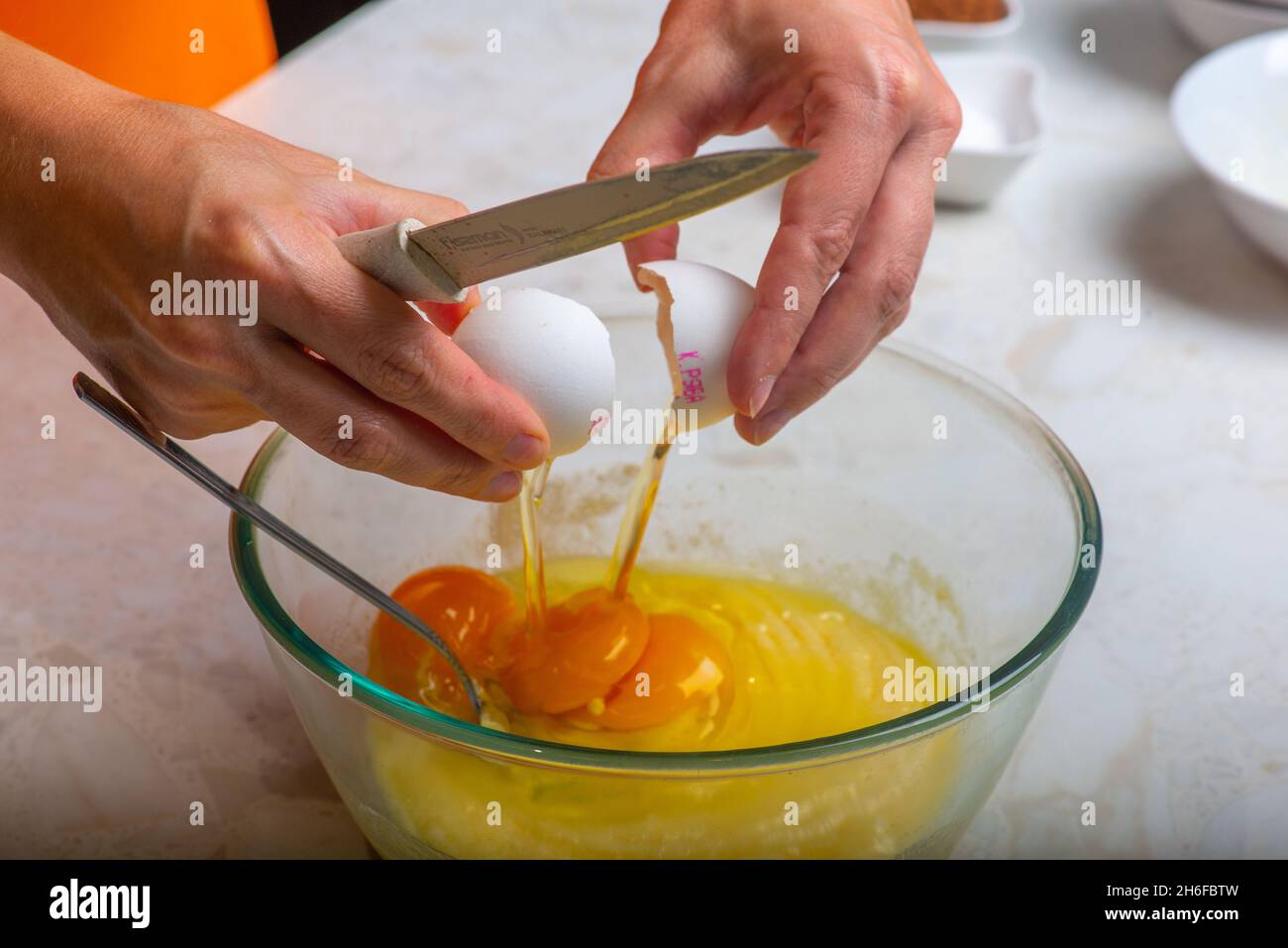 aggiungere tre uova in una tazza con gli ingredienti Foto Stock